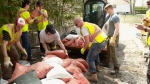 Residents and volunteers pile leftover sandbags into a loader for transportation to the curb in Cumberland, Ont. after flood waters devastated their community in May 2017.(CTV Ottawa)