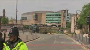 Police officers stand guard outside Manchester Arena on May 23, 2017