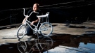 Geoffrey Bercarich poses for a photograph with the ghost bike he painted on roof of his apartment for a five year-old boy who died in a cycling accident in Toronto on Wednesday, May 31, 2017. Bercarich creates ghost bikes for victims who die in bicycles accidents on the street of Toronto. (THE CANADIAN PRESS/Nathan Denette)