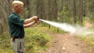 Jon Stuart-Smith demonstrates the proper way to deploy bear spray on a trail off the Bow Valley Parkway in Banff National Park
