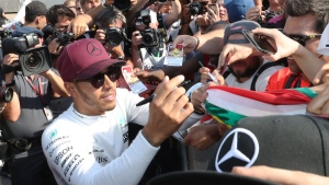 Mercedes driver Lewis Hamilton (44) of Great Britain signs autographs after winning the Canadian Grand Prix Sunday, June 11, 2017 in Montreal. (Paul Chiasson / THE CANADIAN PRESS)