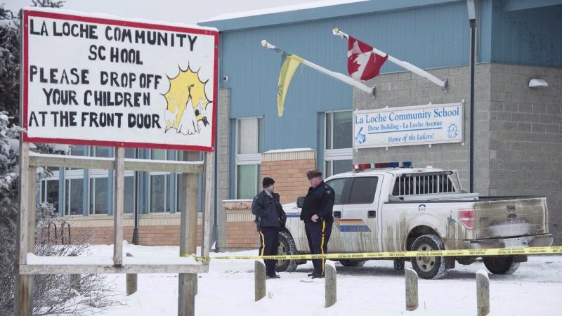 Members of the RCMP stand outside the La Loche Community School in La Loche, Sask. Monday, Jan. 25, 2016. (Jonathan Hayward/The Canadian Press) 