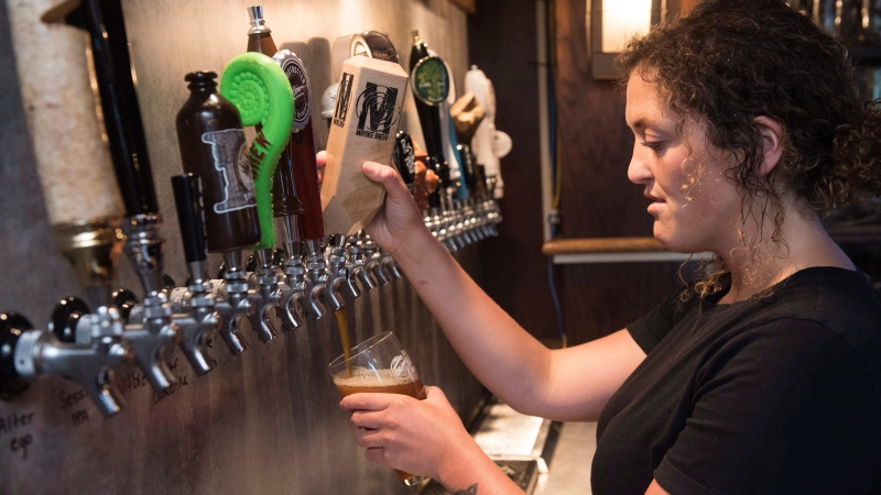 Bartender Jen Atkinson pours a Maybee craft beer at James Joyce Pub in the Crowne Plaza Hotel in Fredericton, N.B., on Friday, June 16, 2017. (Stephen MacGillivray/The Canadian Press) 