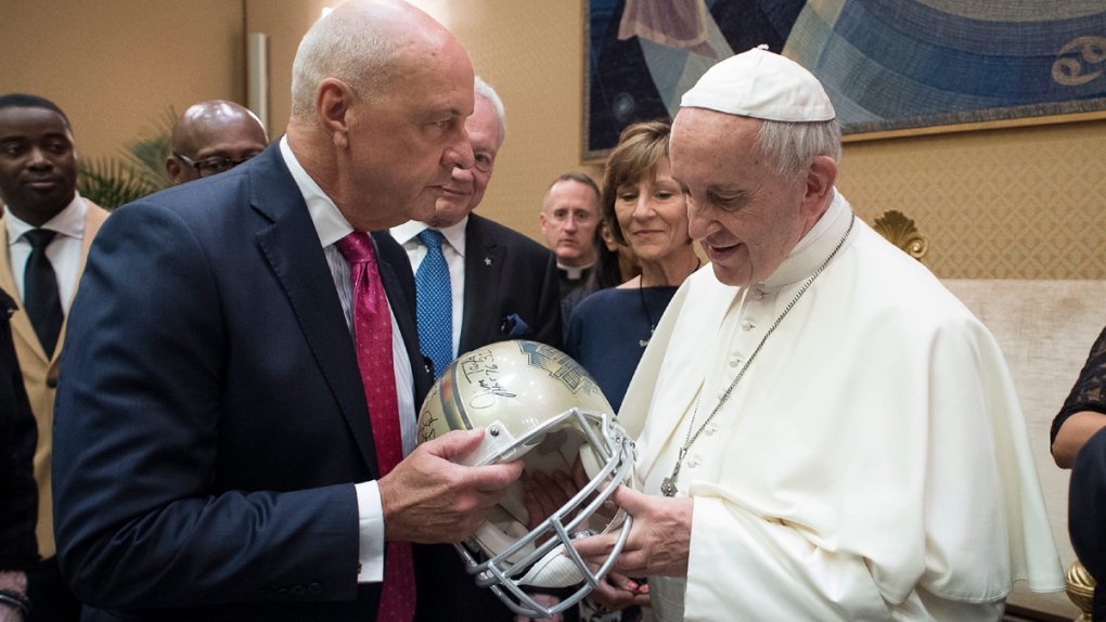 Pope Francis receives a football helmet