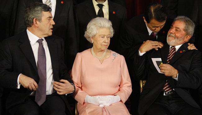 The Queen sits with British Prime Minister Gordon Brown, left, and Brazil's President Luiz Inacio Lula da Silva, right, who talks to Japan's Prime Minister, Taro Aso, top, before a group photograph of G20 leaders at Buckingham Palace in London, Wednesday, April 1, 2009. (AP / Kirsty Wigglesworth)