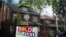 A sold sign is shown in front of west-end Toronto homes, Sunday, May 14, 2017. (Graeme Roy/The Canadian Press)