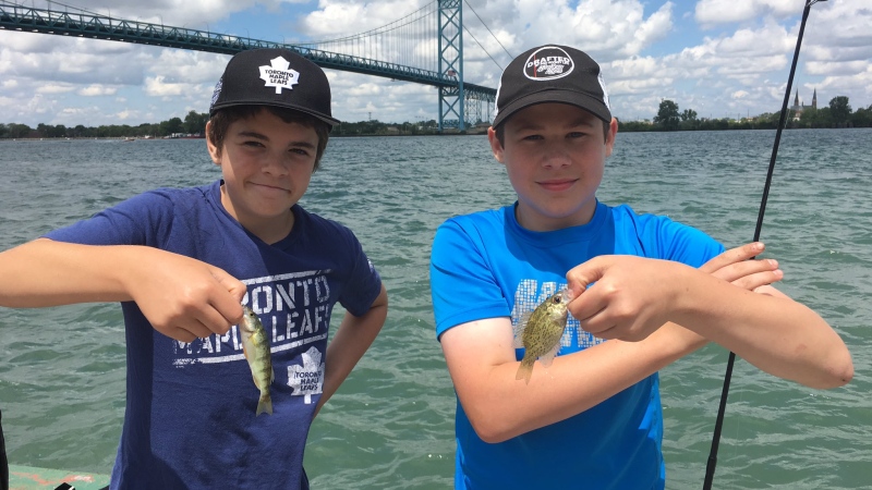 Two boys show off their fish on the Detroit River in Windsor, Ont., on Saturday, July 8, 2017. (Melanie Borrelli / CTV Windsor)