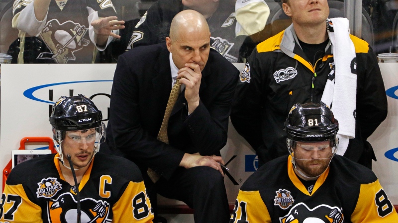 In this file photo, coach Rick Tocchet stands behind Sidney Crosby (87) and Phil Kessel (81) in Pittsburgh, Wednesday, March 29, 2017. (AP / Gene J. Puskar)