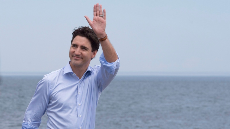 Prime Minister Justin Trudeau waves to people as he walks on the beach, Tuesday, July 18, 2017 at Forillon National Park in Gaspe Que. (THE CANADIAN PRESS/Jacques Boissinot)