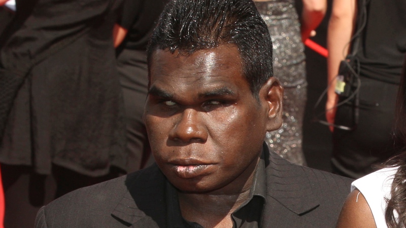 In this Nov. 27, 2011, file photo, aboriginal singer Geoffrey Gurrumul Yunupingu, left, arrives for the Australian Record Industry Association awards in Sydney, Australia. Yunupingu, renowned for singing in his native Yolngu language with a heart-rending voice and a unique guitar-playing style has died, his recording label said Wednesday, July 26, 2017. He was 46. (AP Photo/Rob Griffith, File)