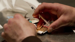 A man prepares heroin he bought on the street to be injected at the Insite safe injection clinic in Vancouver, British Columbia, Canada on Wednesday, May 11, 2011. (Darryl Dyck / THE CANADIAN PRESS)