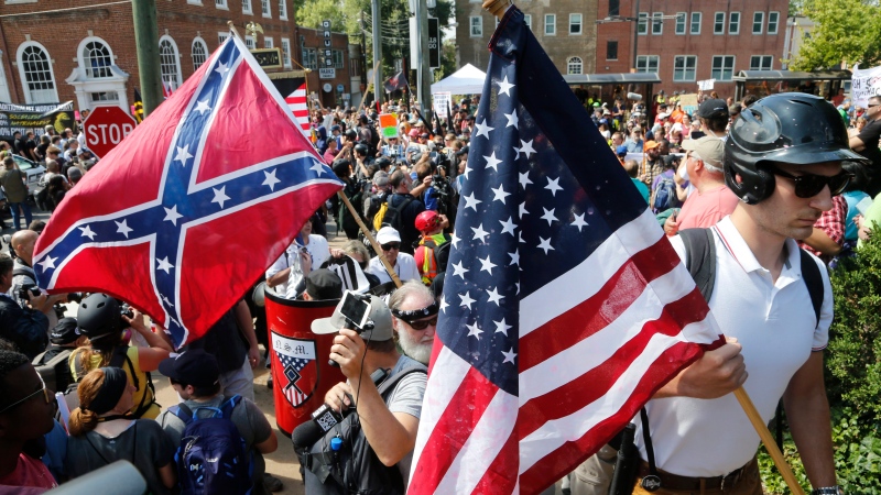 White nationalist demonstrators walk into Lee park surrounded by counter demonstrators in Charlottesville, Va., Saturday, Aug. 12, 2017. (Steve Helber/AP) 