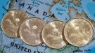 Loonies displayed on a map of North America, on Jan. 9, 2014. (Paul Chiasson / THE CANADIAN PRESS) 