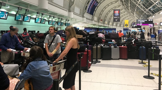 A pile of passengers' baggage is shown at Toronto Pearson International Airport after significant technical issues at Terminal 3 departures. 