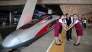 In this June 26, 2017 file photo, railway workers pose for photos with the Fuxing, China's latest high speed train capable of reaching 400 km/h during its maiden service from Beijing. (Chinatopix Via AP, File)