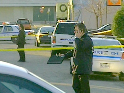 Officials investigate a taped-off area after a house was raided in a police crackdown in Quebec on Wednesday, April 15, 2009.