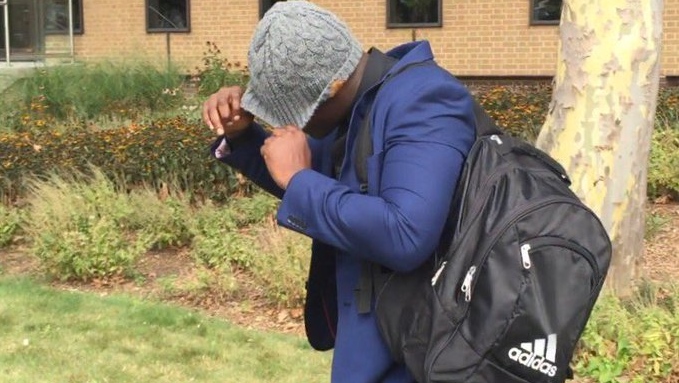 Shadrack Amankwa hides from cameras as he leaves court after being found not guilty of all charges against him in Windsor, Ont., on Thursday, Aug. 24, 2017. (Sacha Long / CTV Windsor)