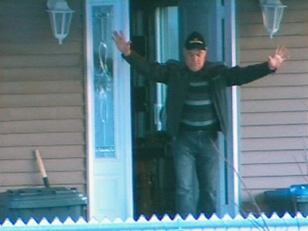 A suspect surrenders to police during a series of raids as part of Operation SharQc in Quebec, Wednesday, April 15, 2009.