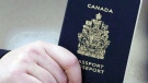 A passenger holds a Canadian passport before boarding a flight in Ottawa on Jan 23, 2007. THE CANADIAN PRESS/Tom Hanson