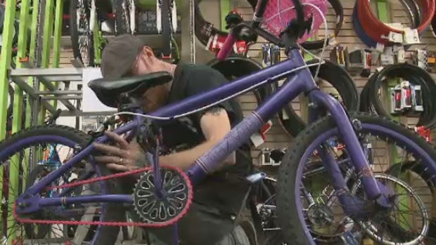 With a wrench, Mark Oulton puts the finishing touches on the girl's bike. 
