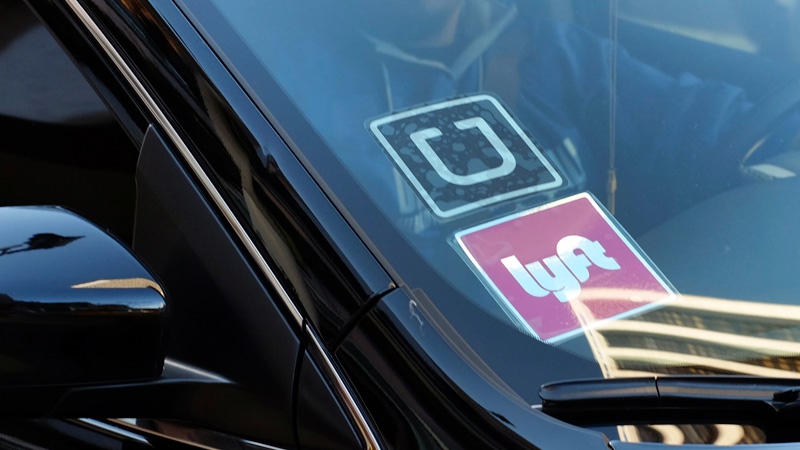 A driver displaying Lyft and Uber stickers 