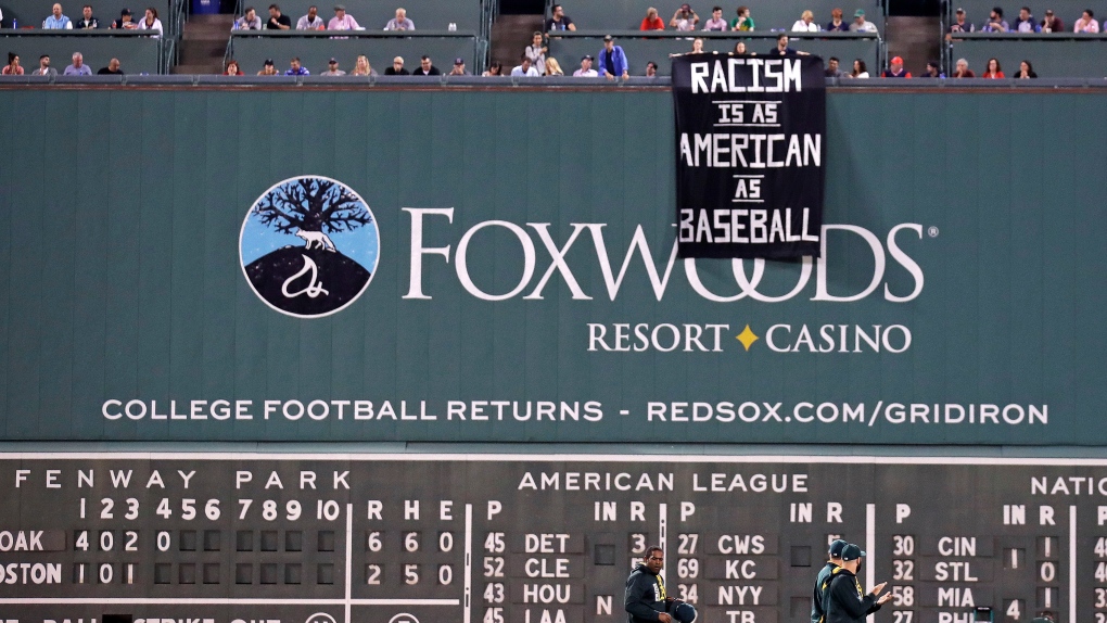 Fans drop a sign at the Green monster 