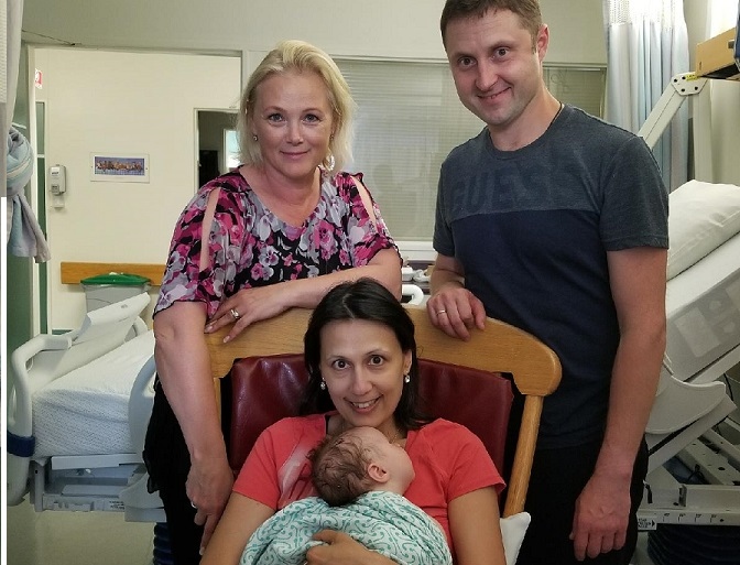 8-week-old Nikita is seen in this photo with mother Oksana (seated) and father Yuriy (standing, right). 