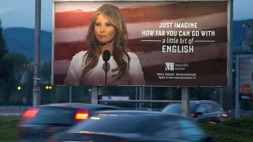 Cars drive past billboard depicting Melania Trump