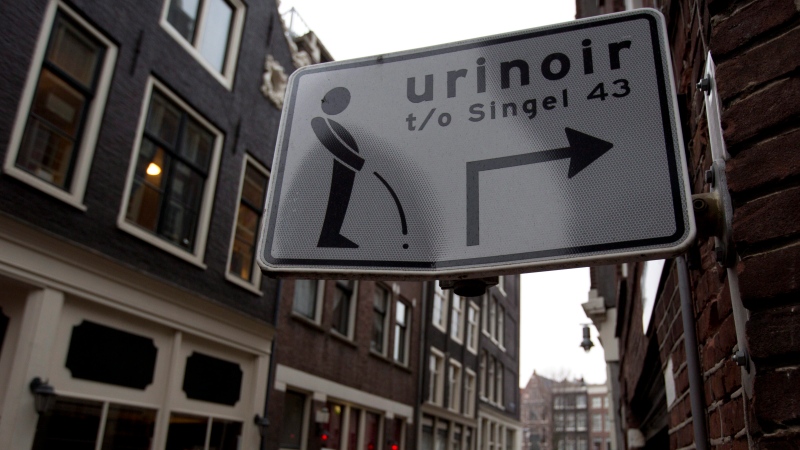 A fairly uncommon road sign point men towards a nearby urinal in an area of Amsterdam, Netherlands on Jan. 19, 2014. (Peter Dejong/AP)