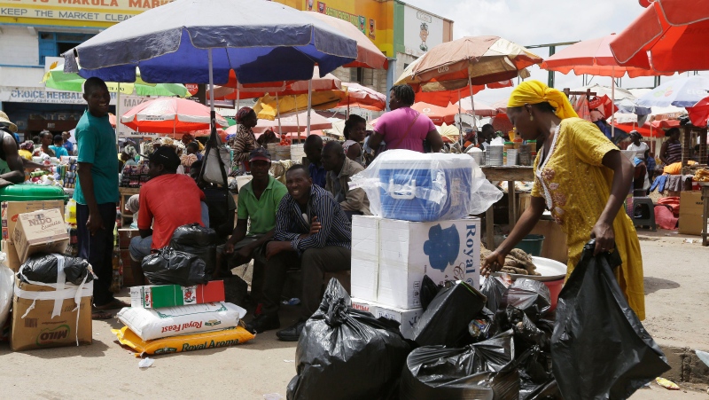 People sit at a central market, in Accra, Ghana, Saturday, June 6, 2015. (AP Photo/Sunday Alamba)