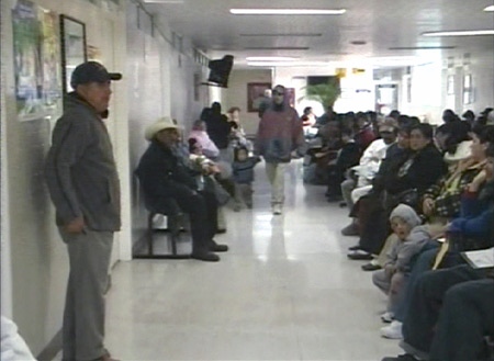 Patients sit in a crowded waiting room at a hospital in Mexico as the number of 'influenza-like' illnesses grows.