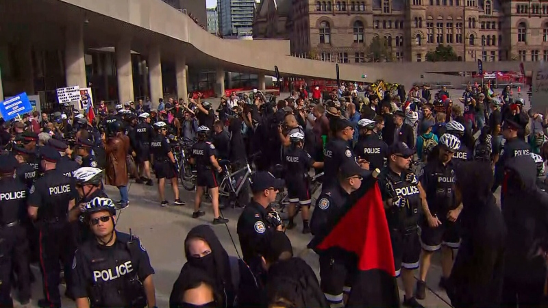 A line of police separate two groups of demonstrators at Nathan Phillips Square on Oct. 21, 2017. (CP24)
