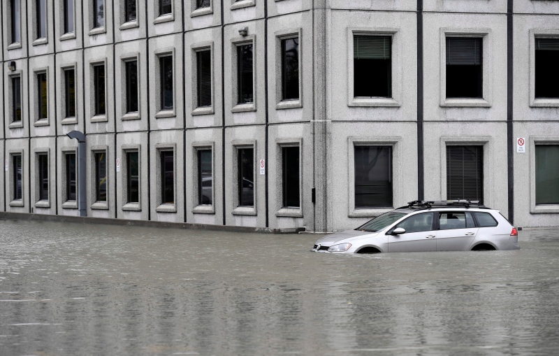 A car sits in the flooded parking lot of the Pebb Building, located across from the Ottawa River, following a rain storm in Ottawa on Monday, Oct. 30, 2017. (Justin Tang/THE CANADIAN PRESS)