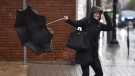 A woman reacts as her umbrella flips inside out as she shields herself from the rain and wind in Ottawa on Monday, Oct. 30, 2017. (Justin Tang/THE CANADIAN PRESS)