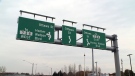 An overhead sign is seen at the entrance to the roundabout at Ottawa Street South and Homer Watson Boulevard in Kitchener.