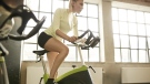 A woman is pictured on a spin bike. (Jacob Ammentorp Lund / Istock.com)