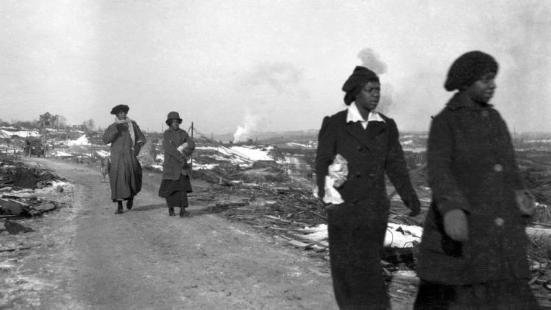 Women from Africville, the black district of Halifax, make their way through the rubble. (City of Toronto Archives)