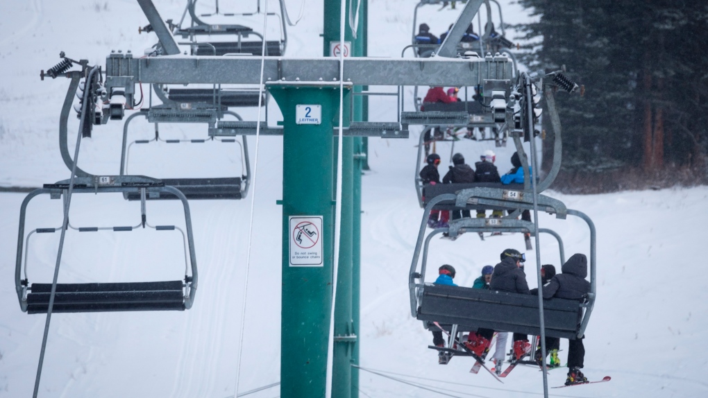 Skiers wait on the chair lift