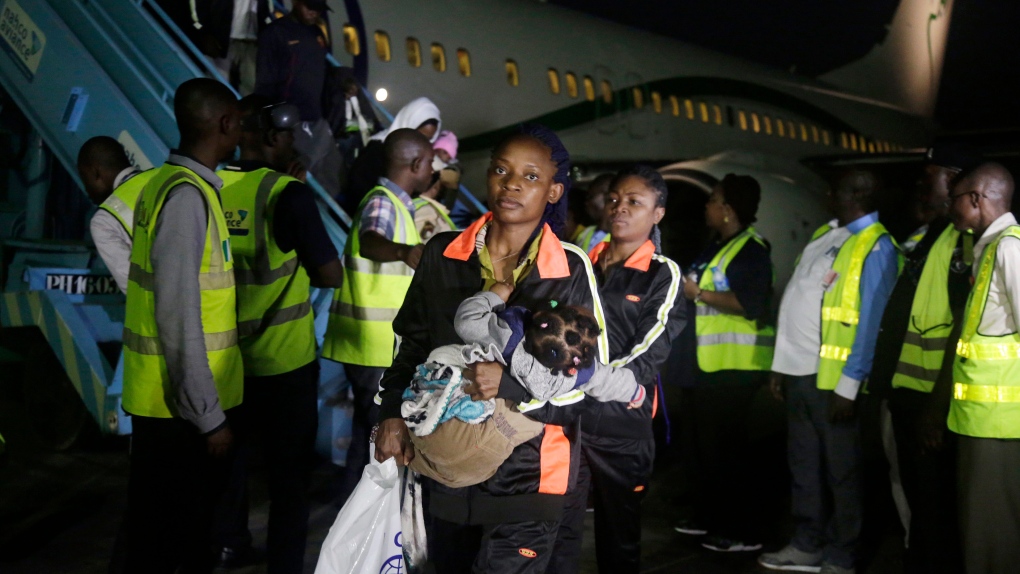 Nigerian returnees from Libya disembark a plane