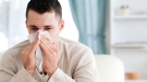 A man with the common cold sneezes into a tissue. (wavebreakmedia ltd/shutterstock.com)