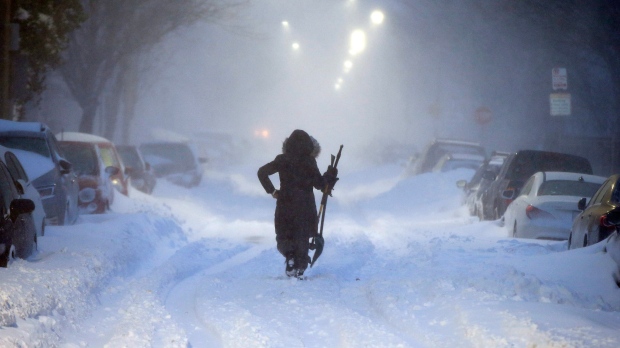 A woman walks down snow-covered Maverick Street in the East Boston neighborhood of Boston, Thursday, Jan. 4, 2018, as a huge winter storm roared up the East Coast with hurricane-force winds, heavy snow and coastal flooding. (AP Photo/Michael Dwyer)