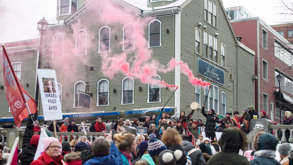 Flares are lit during a Women's March in Halifax