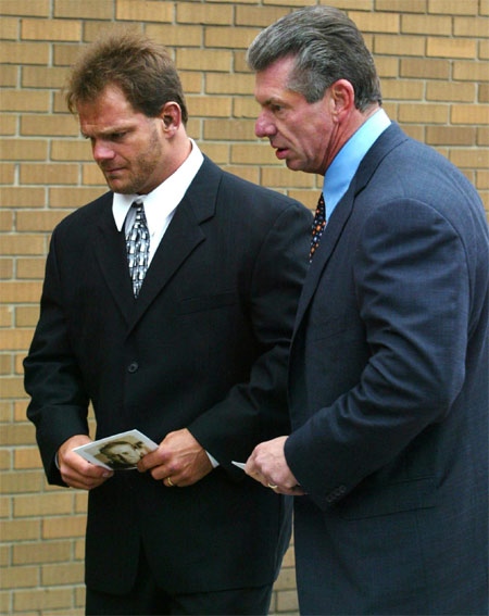 Wrestler Chris Benoit is accompanied by World Wreslting Entertainment Chairman Vince McMahon, to a memorial service for wrestling legend Stu Hart in this Thursday, October 23, 2003 file photo. (CP / Adrian Wyld)