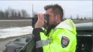 Police officer uses radar gun to help catch speeding drivers. 