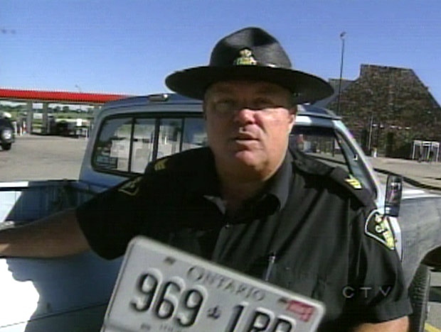 OPP Sgt. Cam Woolley shows off the license plate of a car that was pulled from Highway 400 on Friday, June 29, 2007.