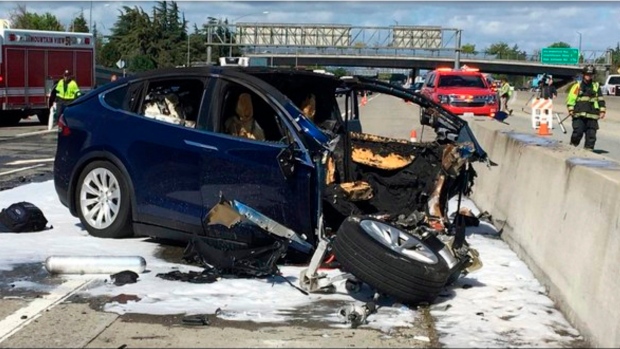 In this March 23, 2018 file photo provided by KTVU, emergency personnel work a the scene where a Tesla electric SUV crashed into a barrier on U.S. Highway 101 in Mountain View, Calif. (KTVU via AP)
