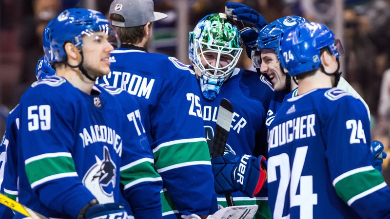 Vancouver Canucks goalie Thatcher Demko, centre, celebrates with teammates Adam Gaudette, back right, and goalie Jacob Markstrom, back left, of Sweden, after defeating the Columbus Blue Jackets 5-4 in overtime NHL hockey action, in Vancouver on Saturday, March 31, 2018. (THE CANADIAN PRESS/Darryl Dyck)