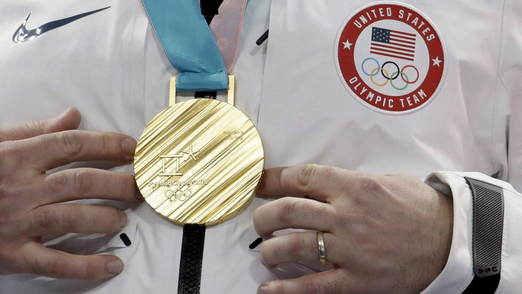 John Shuster touches his Olympic gold medal