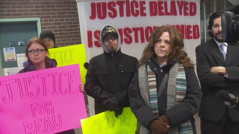 Jackie Baker (foreground) and other supports of her and her son Beau stand in the Kitchener police station on Tuesday, April 3, 2018.