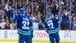 Vancouver Canucks' Henrik Sedin, left, and his twin brother Daniel Sedin wave to the crowd after defeating the Arizona Coyotes 4-3 in their last home NHL hockey game, in Vancouver on Thursday, April 5, 2018. THE CANADIAN PRESS/Darryl Dyck